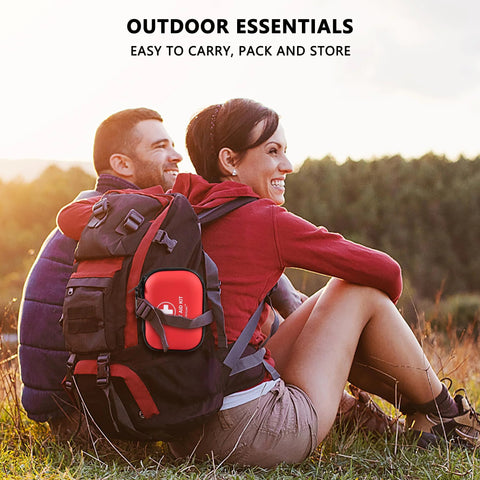 Front view of red mini first aid kit in a waterproof hard-shell case attached to a hiking backpack.
