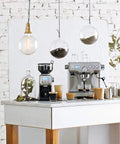 Dual Boiler Espresso Machine in Brushed Stainless Steel Featuring 58mm Commercial Portafilter and Precision Temp Control for Killer Shots and Legit Barista Quality Coffee at Home on a kitchen counter with coffee accessories.