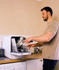 Man loading a pan into the Straight Plug Countertop Dishwasher With No Fuss Setup And Lightning Fast Fifteen Minute Cycle.