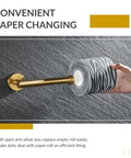 Brushed Dark Gold Stainless Steel Toilet Paper Holder With Round Arm Design in use, mounted on a wall with a roll of toilet paper