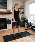 Man using Pro Series Straight Bar For Adjustable Dumbbells Turns Your Home Gym Into A Badass Barbell Setup Expands Weightlifting Curling And Strength Training Options Compatible With Pro Series Dumbbells in home gym.