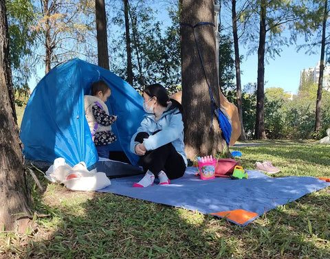Pocket Picnic Blanket For Grab And Go Outdoor Fun That Folds Small And Lightweight Sandproof 55 By 60 Inch Beach Mat in use at a campsite