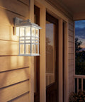 Craftsman Style Outdoor Wall Light In White 12 Inch Tall Exterior Sconce With Clear Hammered Glass glows on porch at dusk