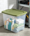 Hella Huge 95 Quart Clear Plastic Storage Bin With Super Grippy Handles for organizing cleaning supplies and linens in garage.
