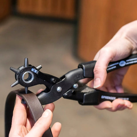 Person using Leather Hole Punch Kit With Easy Squeeze Lever Rotating Punch Wheel German Made Pro Grade Handheld Leather Tool For Precise Holes on a belt