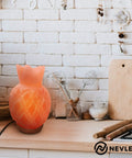 Pineapple-shaped Himalayan salt lamp with warm glow on kitchen counter, surrounded by utensils and decor.