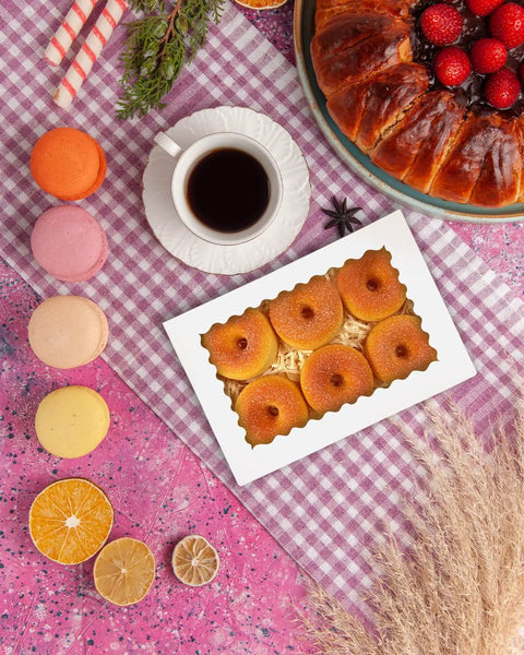 White Bakery Box With Window 9 By 6 By 2.5 Inches Holds 15 Pastries on table with tea and macarons