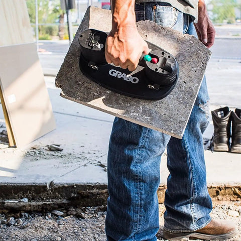 Grab On Pro Electric Suction Cup Lifter holding heavy concrete slab, demonstrating lift aid for pros and dudes at a construction site.