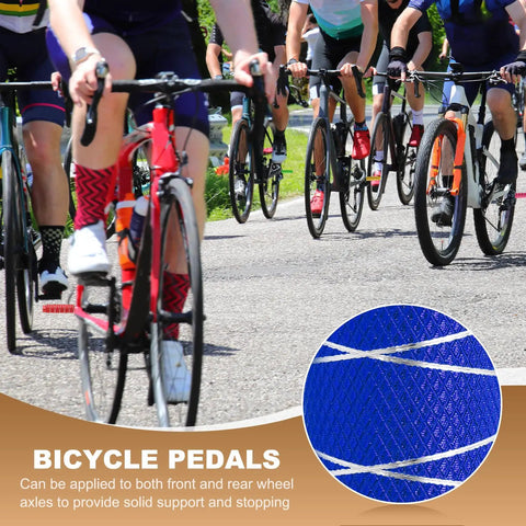 Close-up of navy blue anti-skid aluminum alloy bike pegs insert with cyclists in background.
