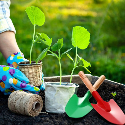 Two 12 Pack Kids Garden Shovels Set With Wooden Handles next to seedlings, showing red and green shovel options for backyard planting.