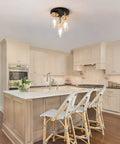 Three-Light Semi Flush Mount Ceiling Light Fixture With Dope Clear Glass Cylinder Shades In Gold Finish in modern kitchen