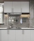 Modern kitchen with Six Pack 5 Inch 128mm Gold and Brushed Satin Nickel Cabinet Pulls on white cabinets, stove, and backsplash.