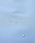Close-up of water droplets on denim blue Women's Waterproof Ski Jacket With Hood, Warm Winter Coat For Snowboarding And Skiing