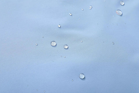 Close-up of water droplets on denim blue Women's Waterproof Ski Jacket With Hood, Warm Winter Coat For Snowboarding And Skiing