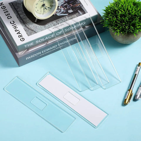 Clear Acrylic Wall Name Plate Holders 15 Pack 2 X 8 Inches shown on desk with adhesive tapes for office use