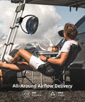 Person relaxing outdoors with an 8 Inch Clip On Fan With 10000mAh Battery, All Day Cordless Power, Strong Airflow, clipped to a tent pole.