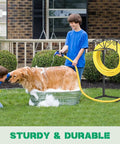 Heavy Duty Garden Hose Holder With 4 Ground Spikes next to boy washing dog in yard, sturdy metal stand holding yellow hose