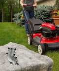 Beefy Gearbox Assembly for 4-Cycle String Trimmer - Replacement Part 753-08122 on rock, shown with red lawn mower nearby