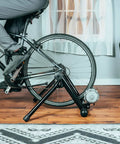 Cyclist using Portable Foldable Fluid Bike Trainer Stand For Indoor Riding With Stainless Steel Frame Near Silent Flywheel