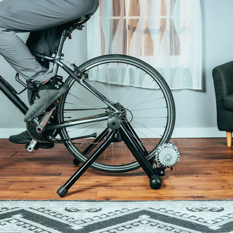 Cyclist using Portable Foldable Fluid Bike Trainer Stand For Indoor Riding With Stainless Steel Frame Near Silent Flywheel