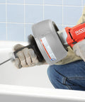 Professional Grade Pneumatic Air Powered 230V Drain Cleaning Tool being used for stubborn residential clogs in a bathtub.
