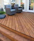 Heavy Duty Wood Stain And Sealer In One For Decks, 5 Gallon semi-transparent finish on a wooden deck with steps and chairs.