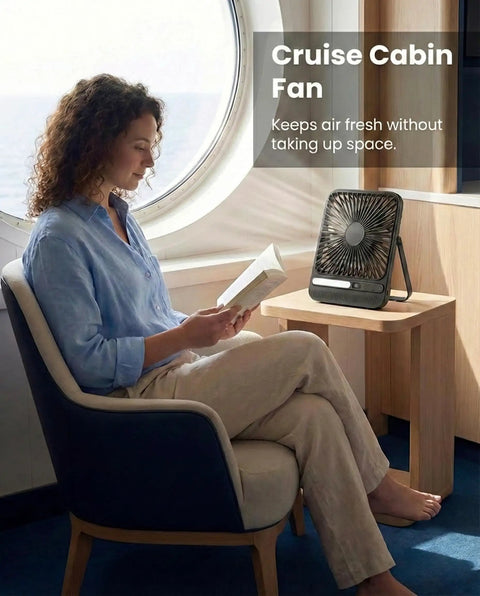 Person reading beside Ultra Thin 7 Inch Portable Travel Fan Must Have With 8000mAh Battery, 28 Hours Runtime, Quiet Rechargeable Desk Fan in cabin.