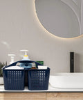 Portable Shower Caddy Organizer With Handle And Three Compartments Offers Zero Hassle Organization With Fast Draining Design Keeps Soaps And Shampoos Straight in navy color, displaying toiletries on a bathroom counter.
