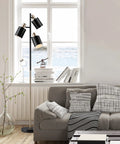 Annecy 58 Inch Rustic Floor Lamp With 3 Lights, Dark Bronze Finish in a modern living room with a grey sofa and window view