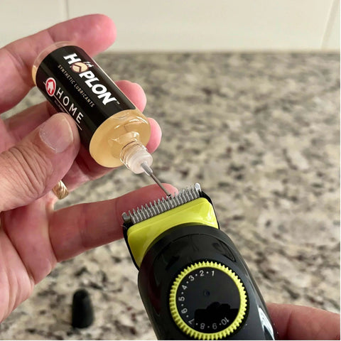 Applying All-In-One 5oz Synthetic Ester Lubricant Spray With Precision Needle to a razor blade for precise lubrication