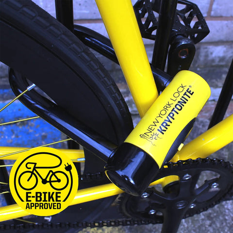 Close-up of yellow New York Fahgettaboutit Mini Bike U Lock With 18mm Hardened Shackle securing bicycle frame, e-bike approved