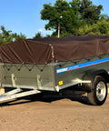 Heavy Duty 16 Mil 10x20 Foot Waterproof Poly Tarp With Brass Grommets And Reinforced Edges on trailer in outdoor setting.