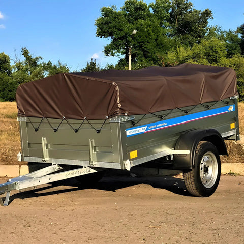 Heavy Duty 16 Mil 10x20 Foot Waterproof Poly Tarp With Brass Grommets And Reinforced Edges on trailer in outdoor setting.