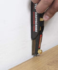 Person using a scribing tool against a wall and floor for accurate markings with Top Shelf 2H Graphite Lead Refills For Tough Drafting And Crisp Blueprint Scribing One Thirty Second Inch Diameter Smooth Action Mechanical Pencil Replacement Pack Of Ten.