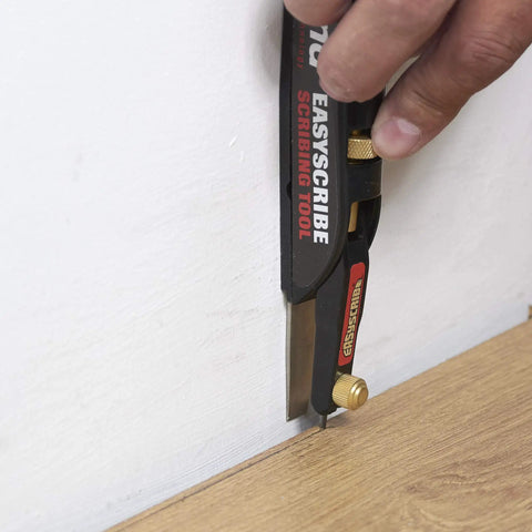 Person using a scribing tool against a wall and floor for accurate markings with Top Shelf 2H Graphite Lead Refills For Tough Drafting And Crisp Blueprint Scribing One Thirty Second Inch Diameter Smooth Action Mechanical Pencil Replacement Pack Of Ten.