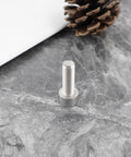 Close-up of a single M6x18mm stainless steel bolt on a marble surface, part of the 4Pcs Bike Crank Arm Pinch Clamp Bolts 304 Stainless Steel M6x18mm Replacement Kit For Shimano Ultegra HollowTech Beefed Up Durable Corrosion Resistant Fasteners.