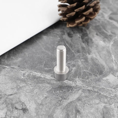 Close-up of a single M6x18mm stainless steel bolt on a marble surface, part of the 4Pcs Bike Crank Arm Pinch Clamp Bolts 304 Stainless Steel M6x18mm Replacement Kit For Shimano Ultegra HollowTech Beefed Up Durable Corrosion Resistant Fasteners.