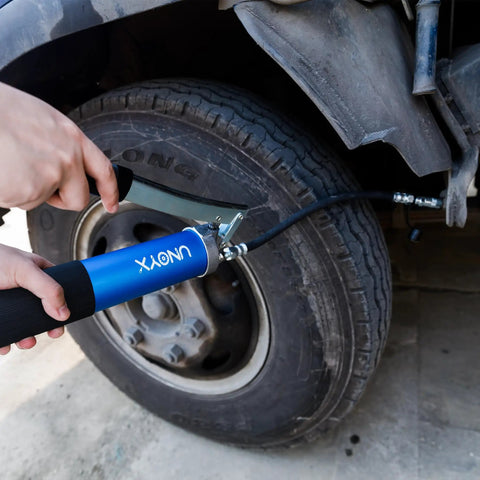 8000 PSI Heavy Duty Lever Action Grease Gun Kit with 14oz Aluminum Barrel being used on vehicle tire.