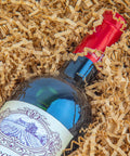 Wine bottle nestled in Crinkle Cut Paper Shred Filler For Gift Baskets And Boxes That Looks Great In Gift Sets Cushion Filler For Christmas