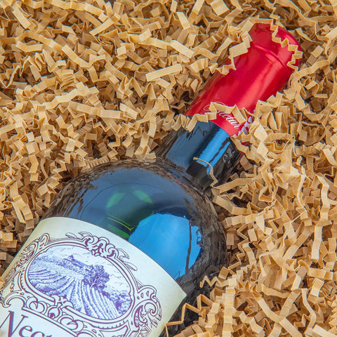 Wine bottle nestled in Crinkle Cut Paper Shred Filler For Gift Baskets And Boxes That Looks Great In Gift Sets Cushion Filler For Christmas