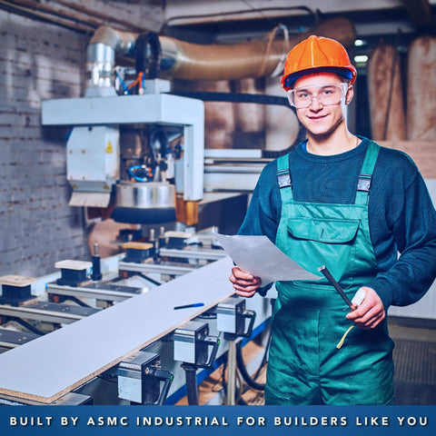 Worker in protective gear holding documents and tools in an industrial workshop setting with machinery.