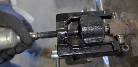 Medium U Joint Puller Tool For Cars Light Trucks And Ag Equipment in use on a driveshaft with heat treated threads visible