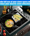 Extra Large Black Marble Stove Top Cover For Electric And Glass Ceramic Cooktops on a kitchen stove, 28.5x20.5 inches, heat resistant.