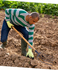 Gardener using Lightweight Manure Fork Compost Fork For Mulching And Multi Function Farm Tool Built Tough For Garden Beds.