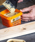 Gorilla Wood Filler tub, orange 16 oz, beige paste scooped with a putty knife (front view).