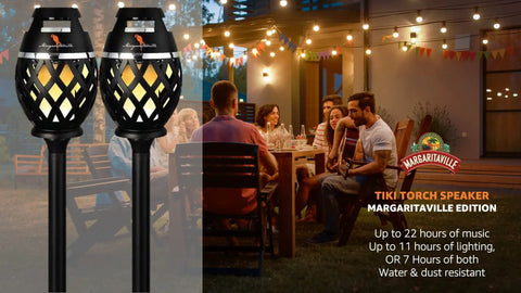 Two-pack waterproof tiki torch Bluetooth speaker near backyard party with flickering LED lights for travel, parties, poolside use