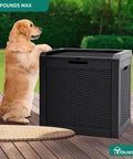 Dog next to 32 Gallon Outdoor Storage Box With Lockable Lid And Side Handles, Waterproof Resin Rattan Deck Box on patio