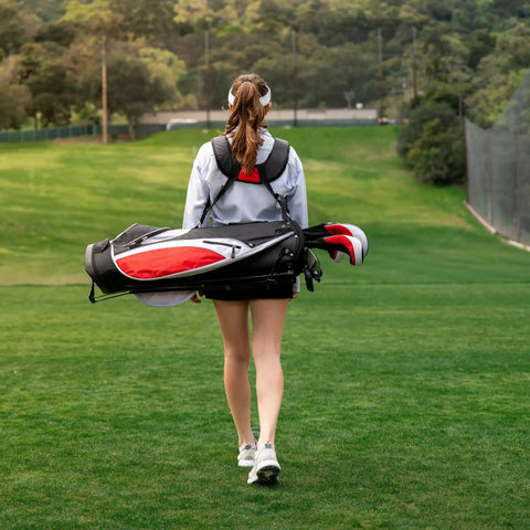 Teen walking on golf course carrying Teen Golf Club Set For Ages 13 To 16 With Titanium Driver, Stainless Hybrid, Stand Bag