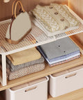 Closet Shelf Organizer Metal Storage Rack for Home Wardrobes with folded linens and handbag, industrial iron frame.