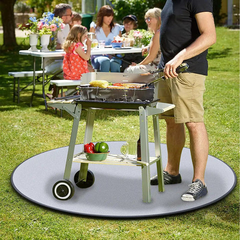 Man grilling on patio with 24 Inch Round Fire Pit Mat Four Layer Fireproof Shield For Outdoor Grills And Decks Waterproof Heat Resistant Protector For Grass And Patio Reusable Under Grill Mat For Camping And Backyard Use under grill.
